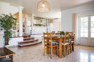 cocina y comedor con mesa y sillas en Villa Castelo de Mar, en Ericeira