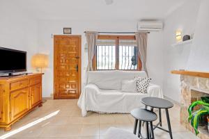 a living room with a couch and a tv at Amor Supremo in Cumbre del Sol