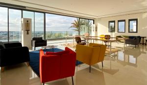um quarto com cadeiras e mesas e uma grande janela em TigMAÏA Guest House In Agadir for Traditional Art and Culture em Agadir