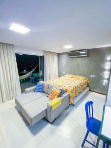 a bedroom with a bed and a couch and a chair at Studio Luxo Ecológico. in Maceió +17 photos