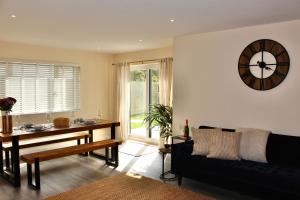 a living room with a table and a clock on the wall at No 1 The Paddock - Spacious holiday home with a hot tub in Bude