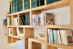 a book shelf filled with lots of books at TigMAÏA Guest House In Agadir for Traditional Art and Culture in Agadir