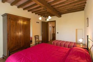 a bedroom with a bed with a red blanket at Oleandro in Santa Luce