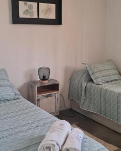 a bedroom with two beds and a table with towels at CASA CAFAYATE LA SOÑADA in Cafayate +24 photos