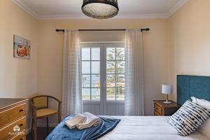 um quarto com uma cama e uma janela em Villa Castelo de Mar na Ericeira