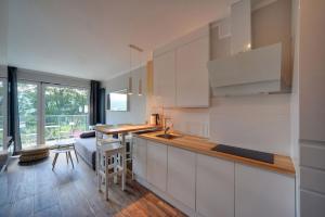 - une cuisine avec des placards blancs et une table dans une pièce dans l'établissement Apart Invest Szklarska 800 - C10, à Szklarska Poręba