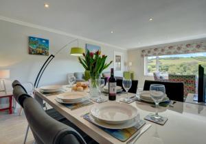 a dining room table with plates and wine glasses at Bay View Bungalow in Combe Martin