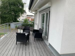 a deck with chairs and tables on a balcony at ALEX-Ferienhaus in Leipzig