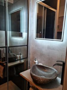 La salle de bains est pourvue d'un lavabo en pierre et de deux miroirs. dans l'établissement La Petite Escale, à Metz