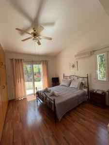 Schlafzimmer mit einem Bett und einem Deckenventilator in der Unterkunft AMAZING VILLA WITH BREATH TAKING VIEWS AND POOL in Limassol