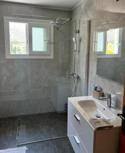 ein Bad mit einem Waschbecken, einer Dusche und einem Spiegel in der Unterkunft AMAZING VILLA WITH BREATH TAKING VIEWS AND POOL in Limassol