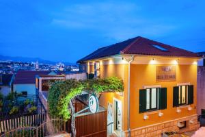 a yellow house with ivy on the side of it at Hygge Rooms Split in Split