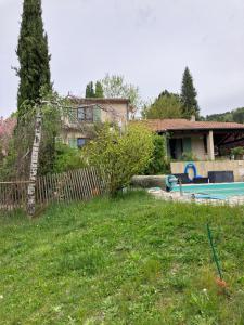 a yard with a house and a swimming pool at La fabrique des petits bonheurs in Dieulefit