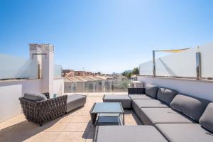 d'une terrasse avec un canapé et une table sur un balcon. dans l'établissement La Perla Pollensa - BY EMERALD STAY, à Port de Pollença