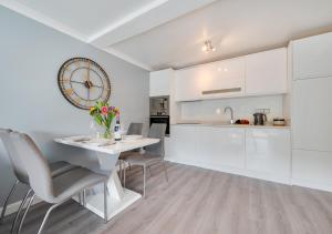 a kitchen with a table and chairs and a clock on the wall at Jacka Shack in Saint Martin