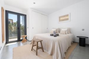 Dormitorio blanco con cama y taburete en La Perla Pollensa - BY EMERALD STAY, en Puerto Pollensa 15 fotos más