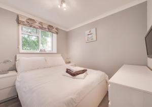 een witte slaapkamer met een bed en een raam bij Jacka Shack in Saint Martin