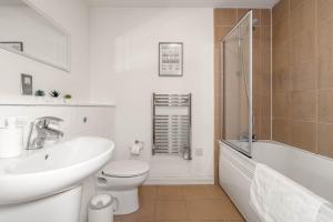 a bathroom with a sink and a toilet and a tub at Opulent 2 Bedroom City Centre Apartment in Nottingham