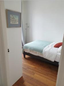 Schlafzimmer mit einem Bett und Holzboden in der Unterkunft Newly renovated apartment near Paris in Clichy