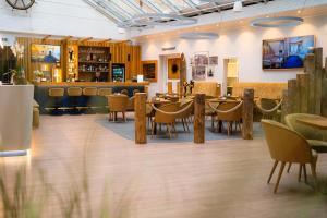 Hotel Am Alten Strom في فارنمونده: مطعم بطاولات وكراسي وبار