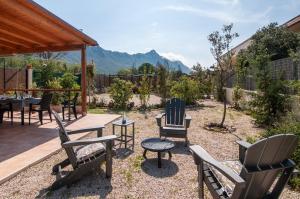 a patio with chairs and a table with mountains in the background at Circeo Holiday Houses in San Felice Circeo