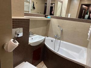 a bathroom with a sink and a tub and a toilet at Last Pub Rynek-Klima-ParkigFree-Netflix-YouTube in Wrocław