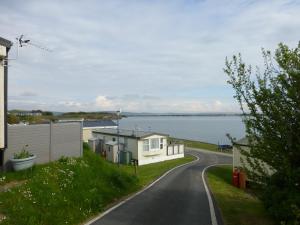 a road leading to a house with a view of the water at 73 Port Haverigg in Millom