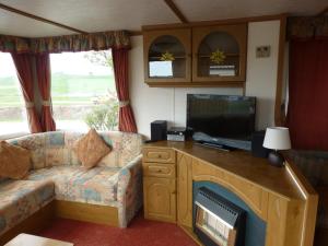 a living room with a couch and a flat screen tv at 73 Port Haverigg in Millom