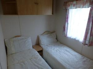 a small room with two beds and a window at 73 Port Haverigg in Millom