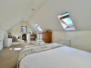 a bedroom with a large bed and a skylight at Beacon Cottage by Inspire Stays in Ditchling