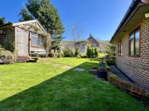 a backyard of a house with a grass yard at Beacon Cottage by Inspire Stays in Ditchling