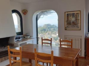 a dining room with a wooden table and a window at Ibiza in Begur
