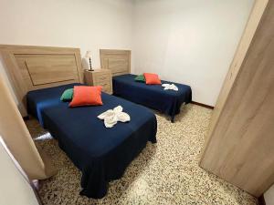 two beds in a hotel room with towels on them at Apartamento Canarias in Los Cristianos