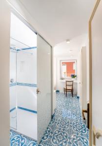 a bathroom with a shower and a tile floor at Hotel Syrene in Capri