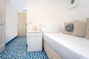 a bedroom with two beds and a blue and white floor at Hotel Syrene in Capri