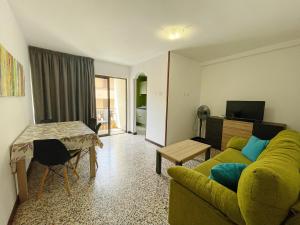 uma sala de estar com um sofá verde e uma mesa em Apartamento Canarias em Los Cristianos