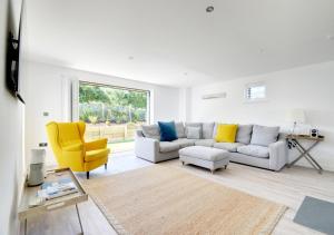 a living room with a couch and a yellow chair at Beach House in Northam