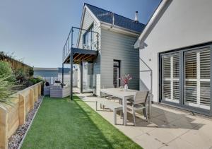 a patio with a table and chairs on the grass at Beach House in Northam