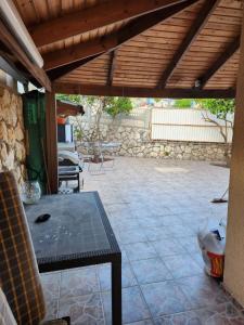 un patio con una mesa y una pared de piedra en בית הנשיא en Safed