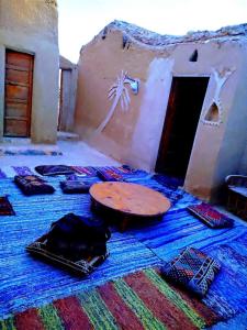 una habitación con una mesa sobre una alfombra y una habitación con una puerta en Nashdeen Eko Lodge, en ‘Izbat Zaydān