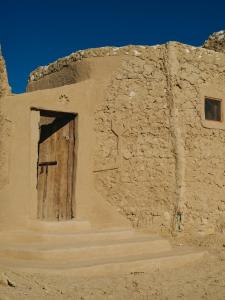 ein Gebäude mit einer Tür und einem Kreuz darauf in der Unterkunft Nashdeen Eko Lodge in ‘Izbat Zaydān