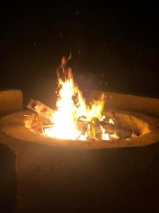 un fuoco brucia in un focolare di notte di Nashdeen Eko Lodge a ‘Izbat Zaydān