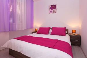 ein Schlafzimmer mit einem großen Bett mit lila Vorhängen in der Unterkunft Apartments Park in Vela Luka