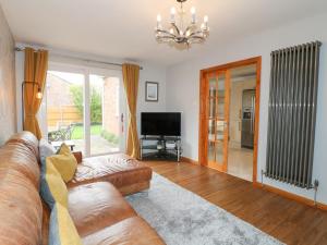 a living room with a couch and a television at Lavender Lodge in Coalville