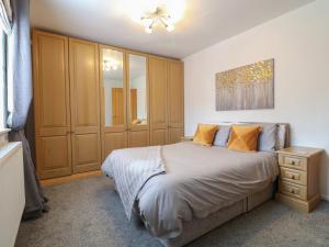a bedroom with a bed and a dresser and a mirror at Lavender Lodge in Coalville