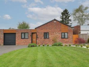 a brick house with a garage at Lavender Lodge in Coalville