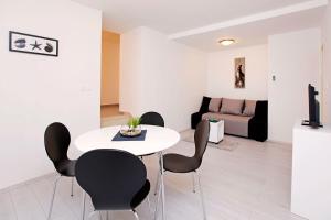 uma sala de estar com uma mesa branca e cadeiras em Apartments Park em Vela Luka