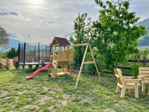 un parque infantil con tobogán y columpio en Agritur Airone Bed & Camping, en Levico Terme