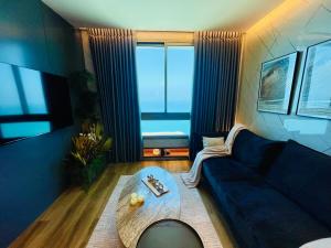 a living room with a blue couch and a table at C Tower Apartments in Netanya