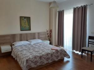 a bedroom with a bed and a large window at Hotel Roberto in Korçë